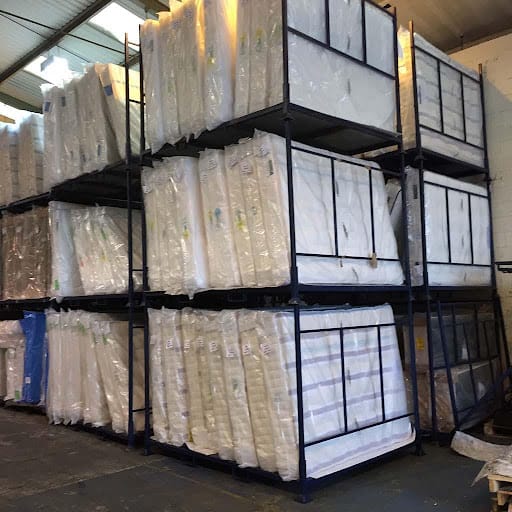mattresses stacked up in a warehouse using mattress stillage