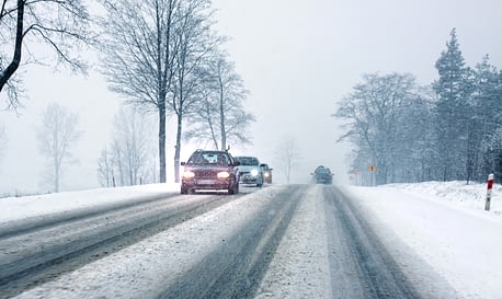 Cars on road in snowy weather conditions