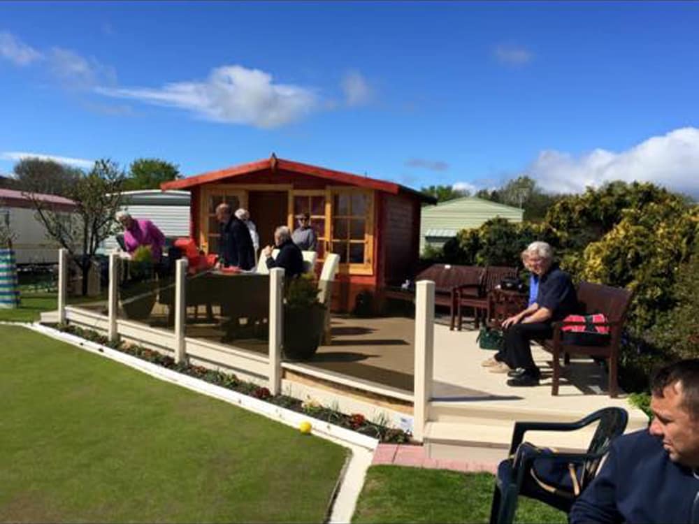 People watching lawn bowling at Pentre Mawr Caravan Park