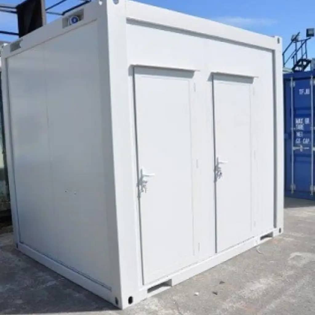 Compact white modular building with two doors, positioned on a solid surface