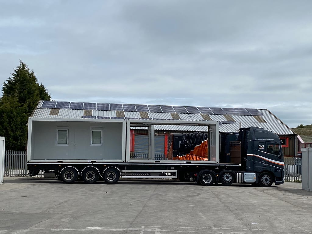 Modular unit with solar panels on a flatbed trailer, ready for delivery