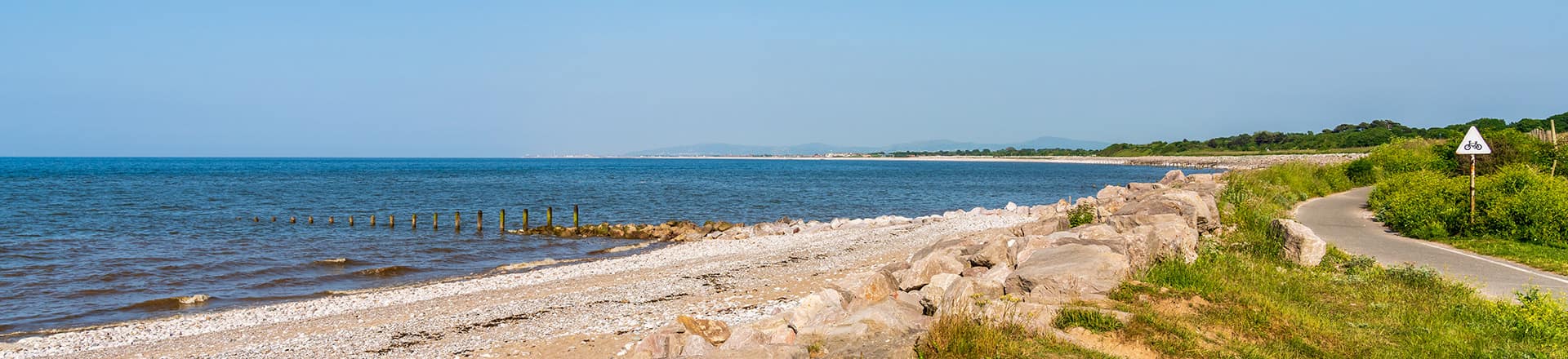 Looking along LLanddulas Beach with blue skies