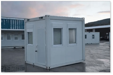 Small, portable gatehouse building on a parking lot.
