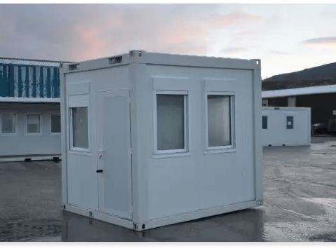 Small, portable gatehouse building on a parking lot.