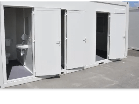 Portable building featuring open doors with a view of toilet and shower facilities inside.