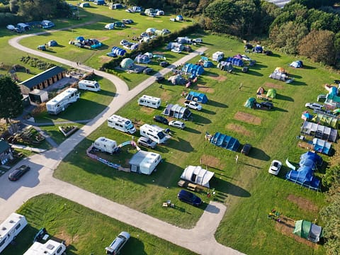 Aerial view of a campsite with tents, caravans, and pathways