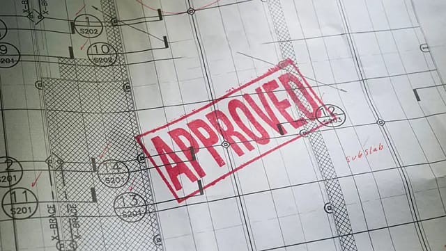 An architectural plan featuring several sections, marked with measurements and notes, stamped with "APPROVED"