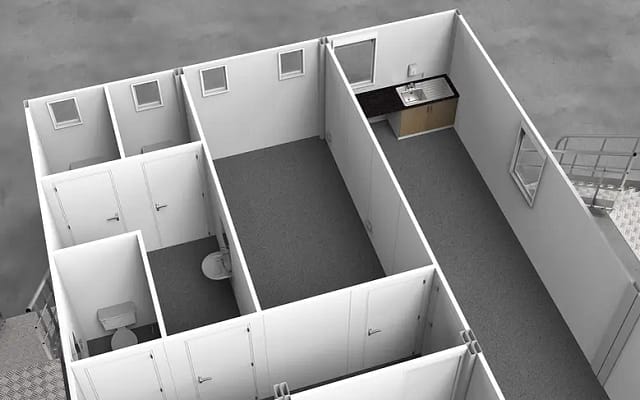 Interior view of a modular building showing partitioned rooms with a kitchenette and a restroom