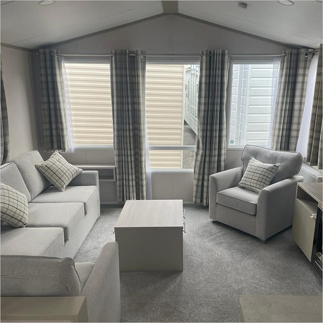 Interior image of caravan showing a lounge area with sofa and armchair