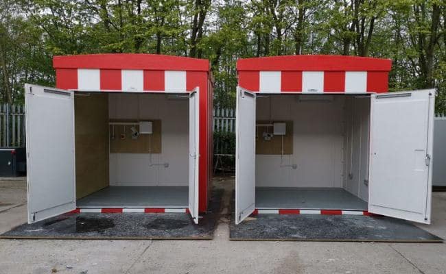ed and white striped cabins with their doors open, revealing simple interiors