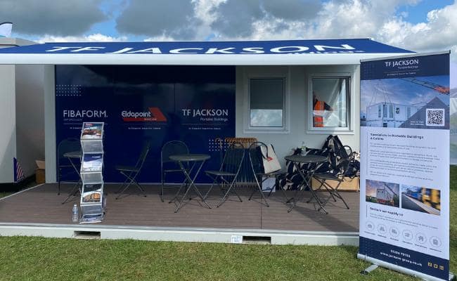 TF Jackson booth at Rail Live 2024 with seating area and informational banners.