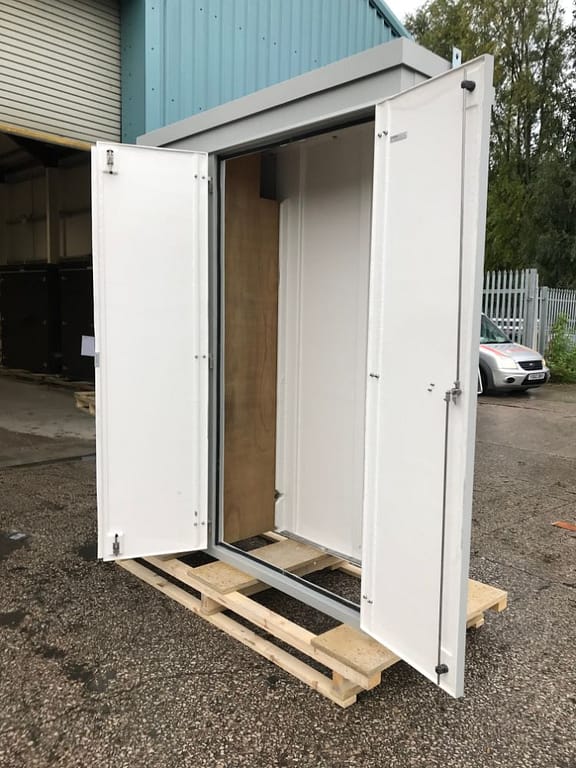 side view of an open gray enclosure with double doors, placed on a wooden pallet