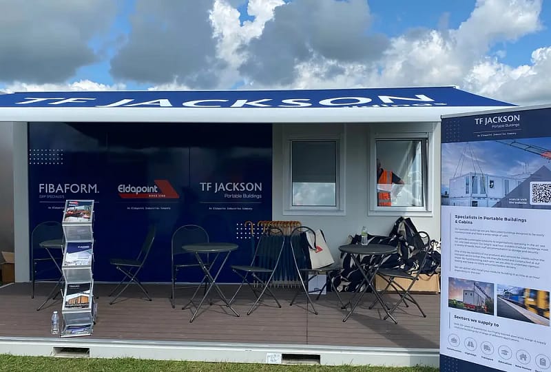 T.F. Jackson branded trade show stand featuring portable buildings, under a partly cloudy