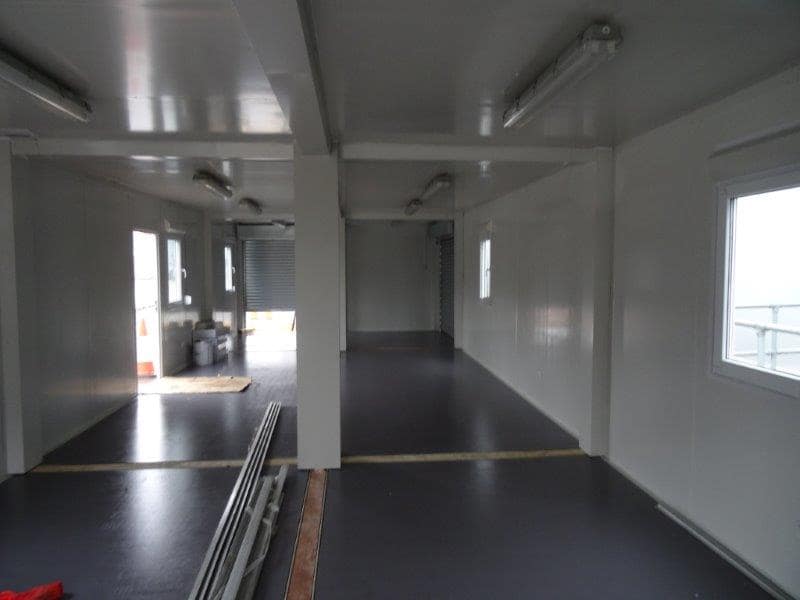 Spacious interior of a modular building with multiple support columns and large windows