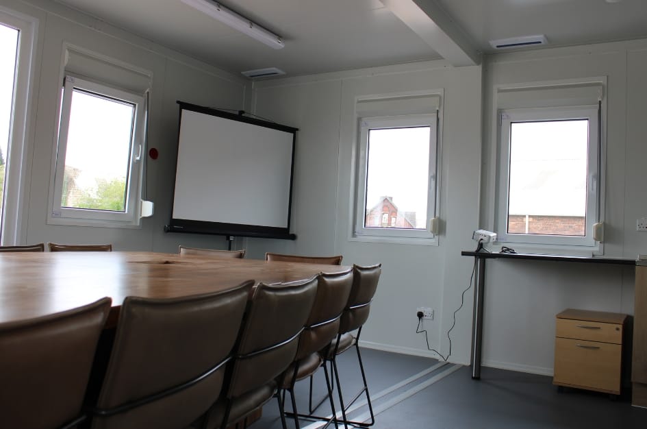 Interior shot of ADS Truckstop's new meeting room, with projector and screen and large meeting table