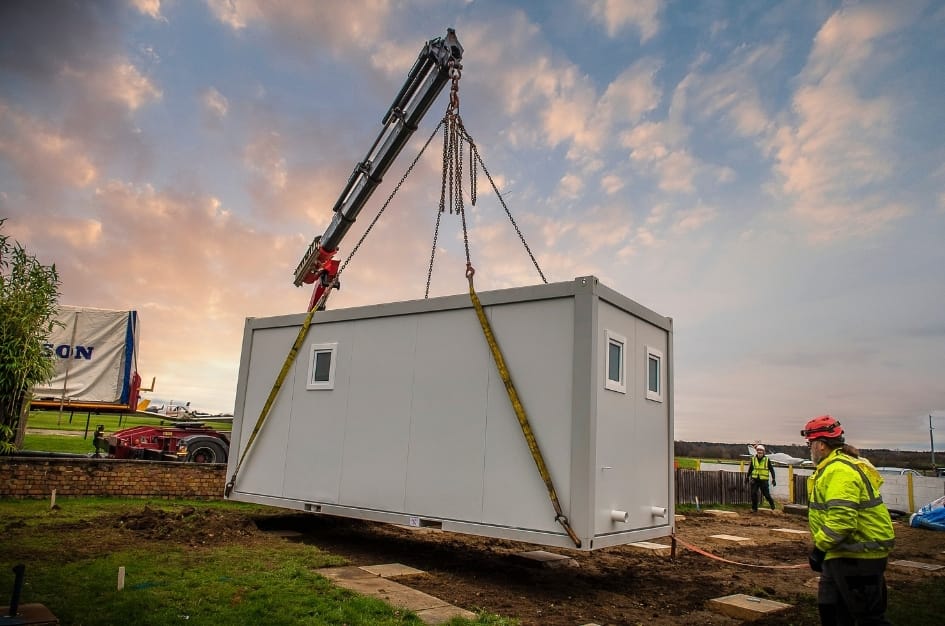Fairoaks Airport's first section of it's new building  lands in place, overlooked by the TF Jackson team