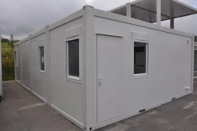 Exterior of a modular building with multiple windows, set in an outdoor environment